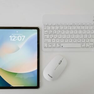 Modern workspace featuring a tablet, wireless keyboard, and mouse on a clean surface.