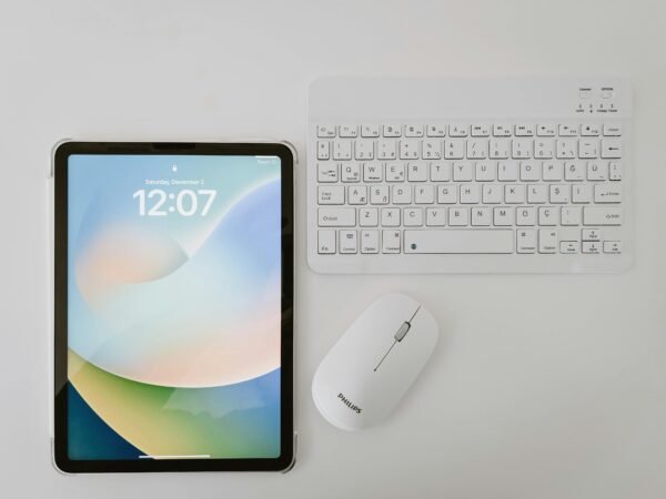 Modern workspace featuring a tablet, wireless keyboard, and mouse on a clean surface.