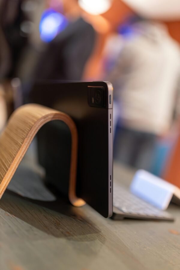 A sleek tablet on a stylish wooden stand with a wireless keyboard, showcasing modern technology and design.