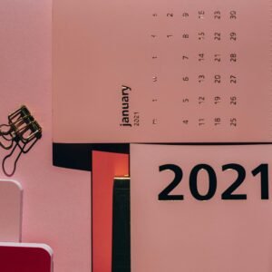 Overhead view of contemporary calendar with weekly dates near metal clips on office desk