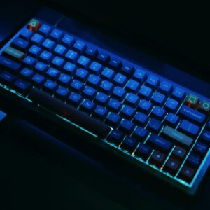 A close-up view of an illuminated mechanical gaming keyboard with RGB lighting.