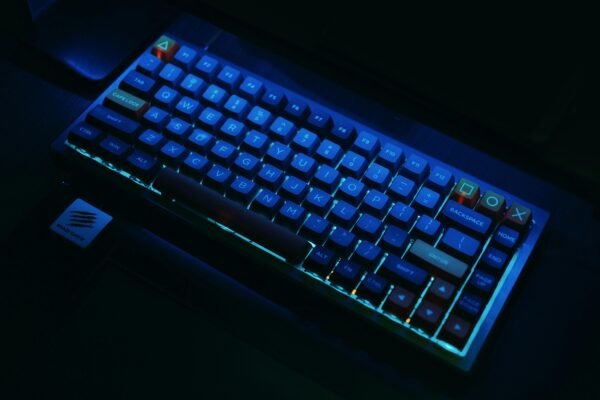 A close-up view of an illuminated mechanical gaming keyboard with RGB lighting.